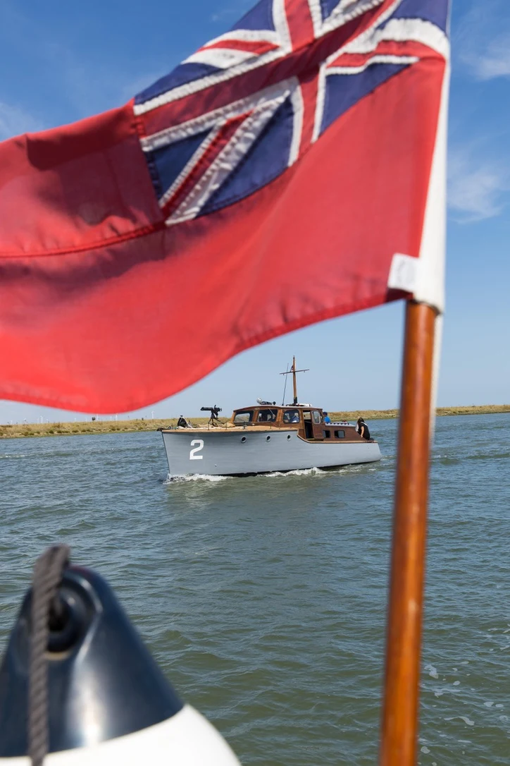 Gerfalcon seen beneath a Red Ensign